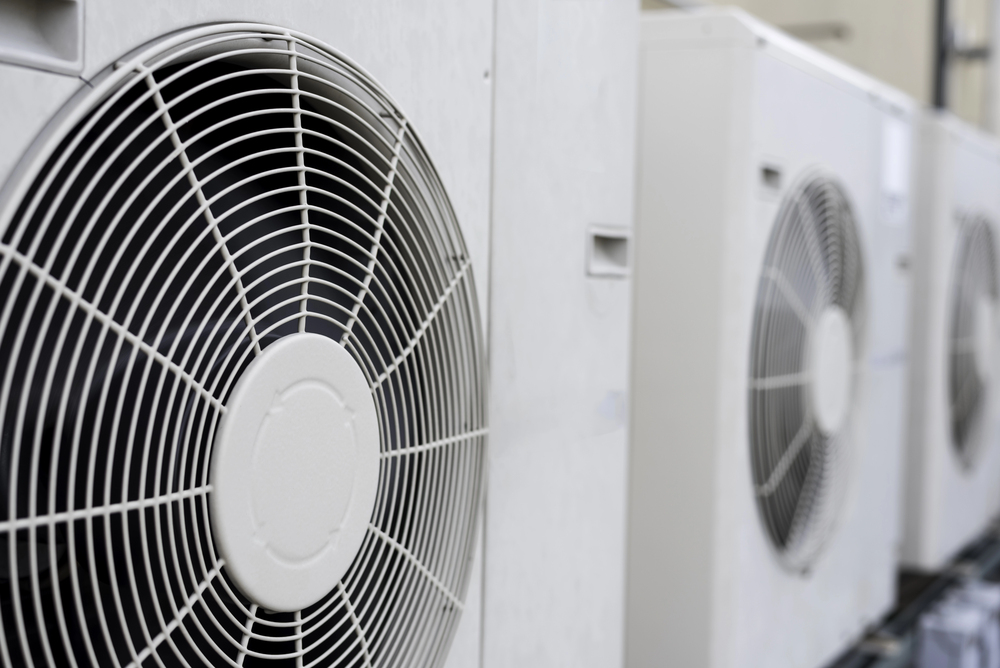 Close-up view of multiple outdoor air conditioning units with visible fan grills.